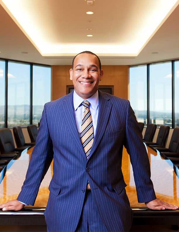 portrait of african american ceo smiling in pinstripe suit in front of conference table 