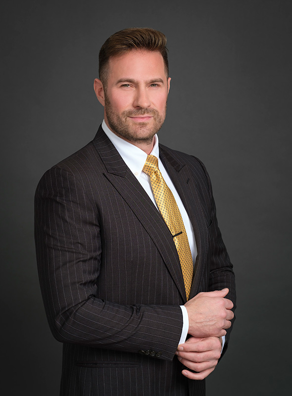 Real Estate Agent headshots photographed in studio with black background wearing a suit.